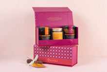 Pink gift box with Aamra  honey and candle products on a pink background